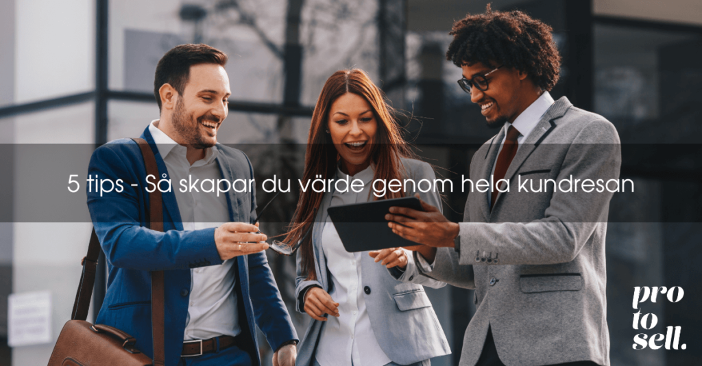 två affärsmän och en affärskvinna ler och tittar på en ipad